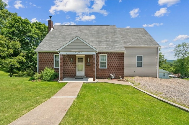 585 Dugan Way, New Kensington, PA 15068 - cape cod house featuring brick siding, a front lawn, and a chimney