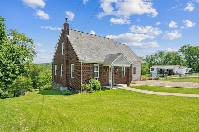 585 Dugan Way, New Kensington, PA 15068 - view of front of house featuring a front yard, brick siding, a shingled roof, and a chimney