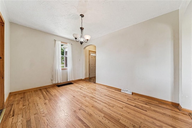 585 Dugan Way, New Kensington, PA 15068 - unfurnished room featuring arched walkways, light wood-style floors, and a textured ceiling