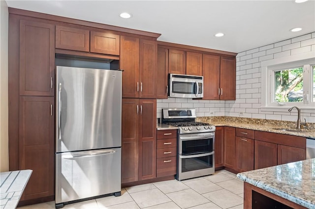 1216 Laclair Ave, Regent Square, PA 15218 - kitchen featuring stainless steel appliances, light stone counters, light tile patterned flooring, recessed lighting, and tasteful backsplash