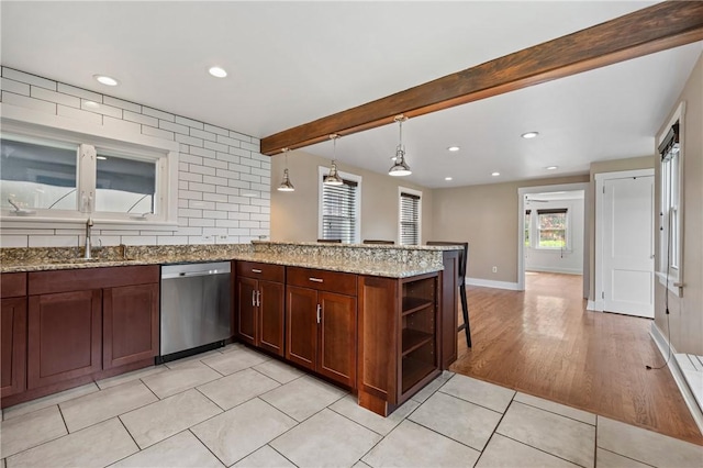1216 Laclair Ave, Regent Square, PA 15218 - kitchen with stainless steel dishwasher, light tile patterned floors, a breakfast bar area, a peninsula, and light stone counters