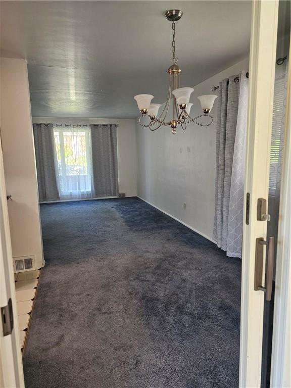 46 Corbett Ave, Hempfield Twp Wml, PA 15642 - empty room with dark carpet and a chandelier