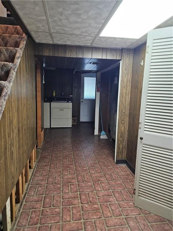 46 Corbett Ave, Hempfield Twp Wml, PA 15642 - hall with wood walls, brick patterned floors, and washer and dryer