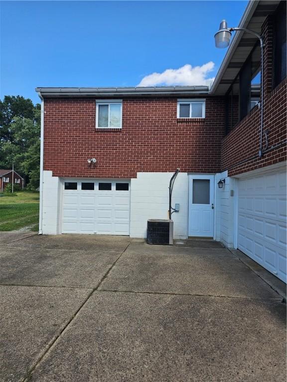 46 Corbett Ave, Hempfield Twp Wml, PA 15642 - view of home's exterior with an attached garage, concrete driveway, and brick siding