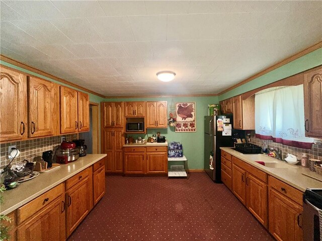 3246 Old Mcclellandtown Rd, Pa, PA 15458 - kitchen with stainless steel appliances, brown cabinetry, light countertops, backsplash, and dark colored carpet