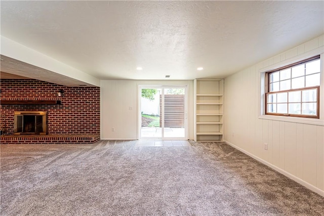 25 Nottingham Dr, Hempfield Twp, PA 15601 - unfurnished living room featuring carpet, built in shelves, a brick fireplace, and a textured ceiling