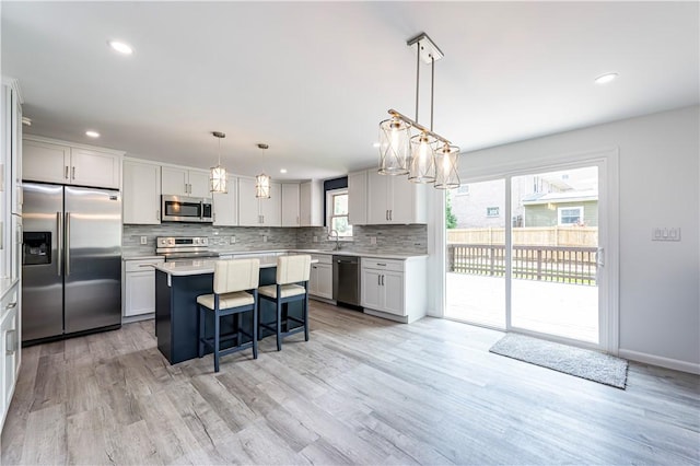 25 Nottingham Dr, Hempfield Twp, PA 15601 - kitchen featuring stainless steel appliances, backsplash, a kitchen island, light countertops, and a breakfast bar area