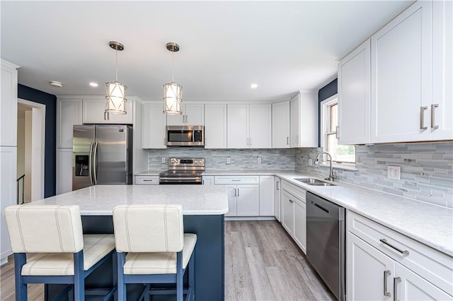 25 Nottingham Dr, Hempfield Twp, PA 15601 - kitchen featuring appliances with stainless steel finishes, light wood finished floors, a kitchen bar, decorative backsplash, and recessed lighting