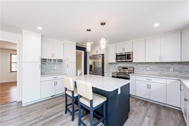 25 Nottingham Dr, Hempfield Twp, PA 15601 - kitchen featuring stainless steel appliances, a breakfast bar area, light wood-style flooring, tasteful backsplash, and white cabinetry