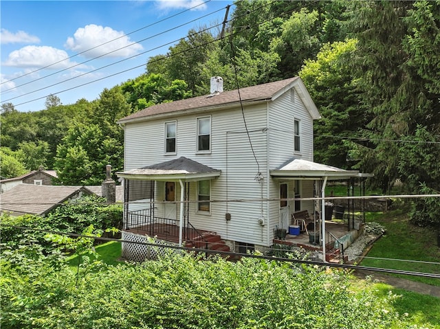 3114 30th St, Pulaski Twp Bea, PA 15066 - view of front of home featuring a chimney, a patio, a front lawn, and a wooded view