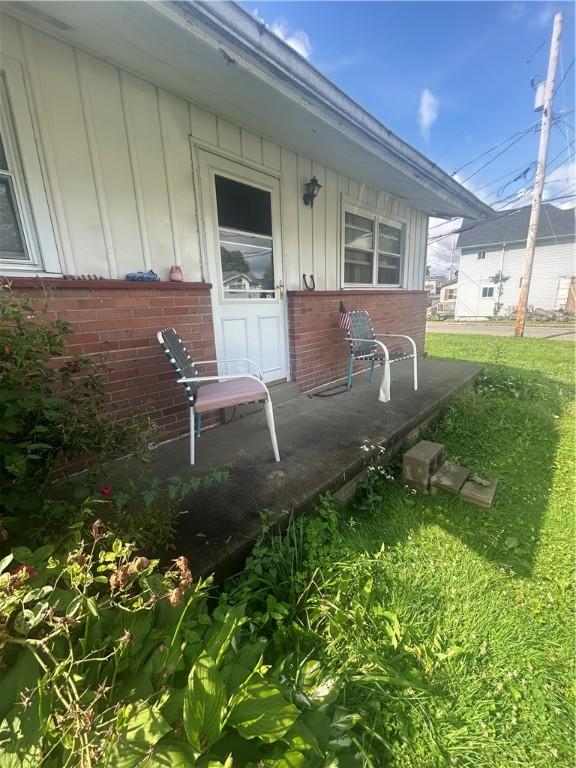 100 Quarry St, Rochester, PA 15074 - property entrance with board and batten siding, brick siding, covered porch, and a lawn