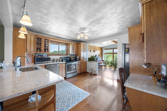 367 Crescent Dr, Canton Twp, PA 15301 - kitchen with stainless steel appliances, brown cabinetry, wood finished floors, and light stone counters