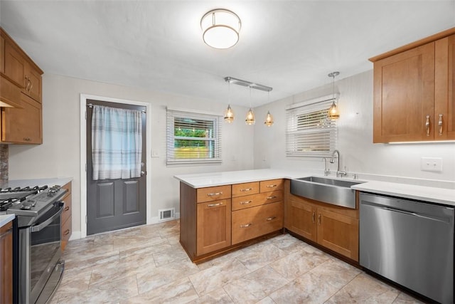 3960 Millers Run Rd, Cecil, PA 15057 - kitchen featuring stainless steel appliances, a peninsula, brown cabinets, light countertops, and pendant lighting