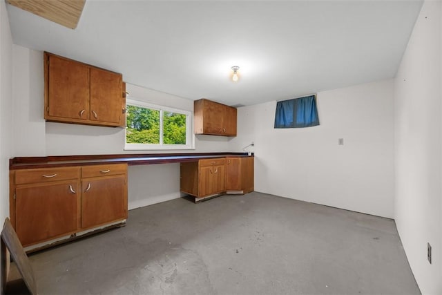 3960 Millers Run Rd, Cecil, PA 15057 - kitchen with finished concrete floors, brown cabinetry, built in study area, and dark countertops