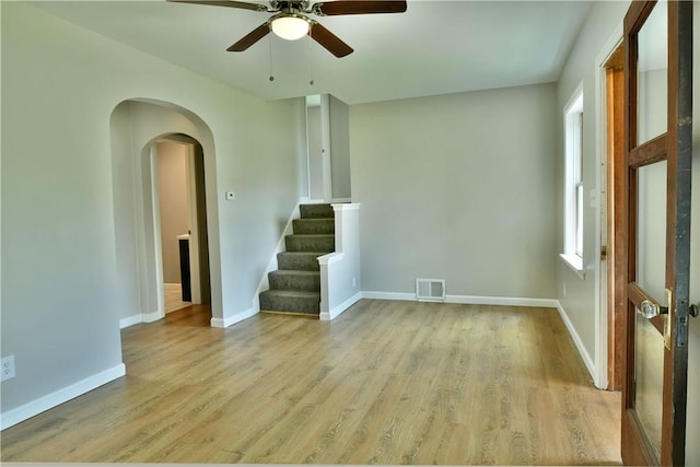 49 N Oakdale Ave, Hermitage, PA 16148 - empty room featuring light wood-style flooring, stairs, a ceiling fan, and arched walkways
