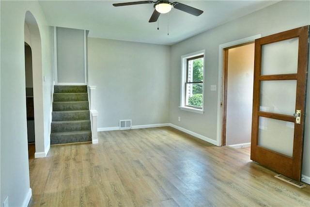 49 N Oakdale Ave, Hermitage, PA 16148 - unfurnished room with arched walkways, wood finished floors, ceiling fan, and stairs