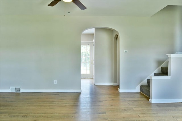 49 N Oakdale Ave, Hermitage, PA 16148 - unfurnished room with arched walkways, a ceiling fan, wood finished floors, and stairs