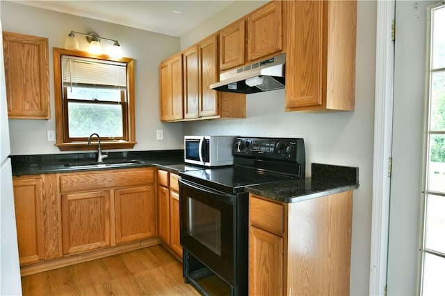 49 N Oakdale Ave, Hermitage, PA 16148 - kitchen with under cabinet range hood, black range with electric cooktop, white microwave, light wood-style floors, and dark stone countertops