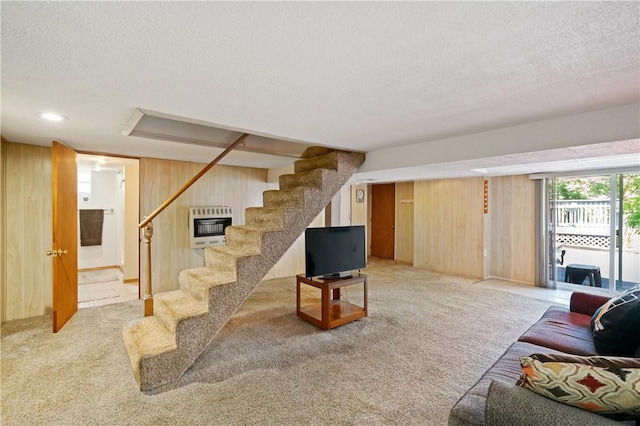 2534 Jefferson Ave, West Mifflin, PA 15122 - living room featuring heating unit, stairs, wood walls, light colored carpet, and a textured ceiling