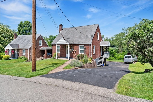 2534 Jefferson Ave, West Mifflin, PA 15122 - bungalow with brick siding, a chimney, a front lawn, roof with shingles, and driveway