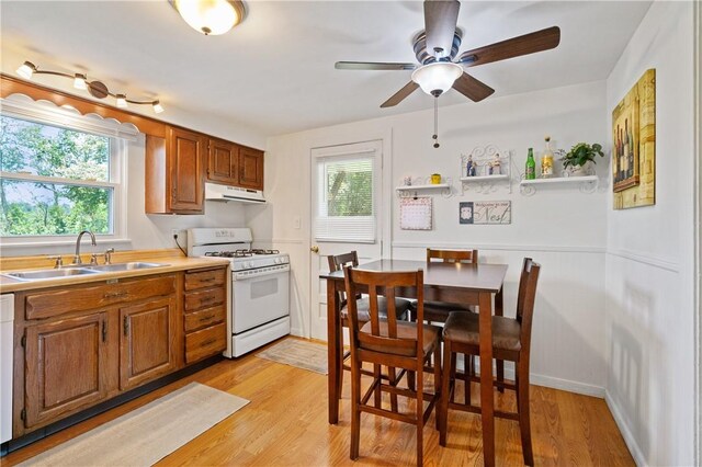 2534 Jefferson Ave, West Mifflin, PA 15122 - kitchen featuring white appliances, under cabinet range hood, a ceiling fan, plenty of natural light, and wainscoting