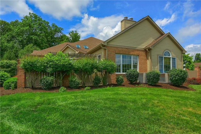 135 Linden Ct, Seven Fields Boro, PA 16046 - view of front facade with brick siding, a chimney, and a front yard