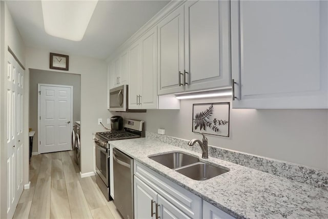 135 Linden Ct, Seven Fields Boro, PA 16046 - kitchen featuring stainless steel appliances, independent washer and dryer, light wood-type flooring, white cabinetry, and light stone counters