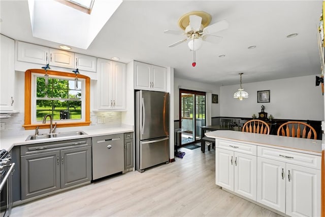 236 Fredonia Rd, Hempfield Twp Mer, PA 16125 - kitchen with appliances with stainless steel finishes, gray cabinetry, decorative backsplash, ceiling fan, and light wood finished floors