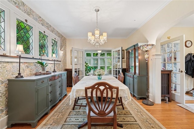 35 Pleasant Valley Rd, Hempfield Twp Wml, PA 15644 - dining area featuring a chandelier, light wood-style flooring, arched walkways, and crown molding