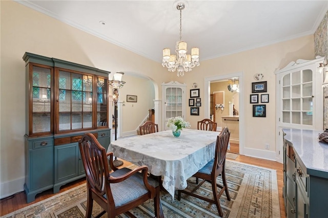 35 Pleasant Valley Rd, Hempfield Twp Wml, PA 15644 - dining space featuring a chandelier, arched walkways, light wood finished floors, and crown molding