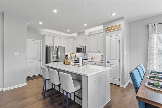 134 Black Oak Ln, Cecil, PA 15057 - kitchen featuring stainless steel appliances, a kitchen breakfast bar, dark wood-type flooring, light countertops, and an island with sink