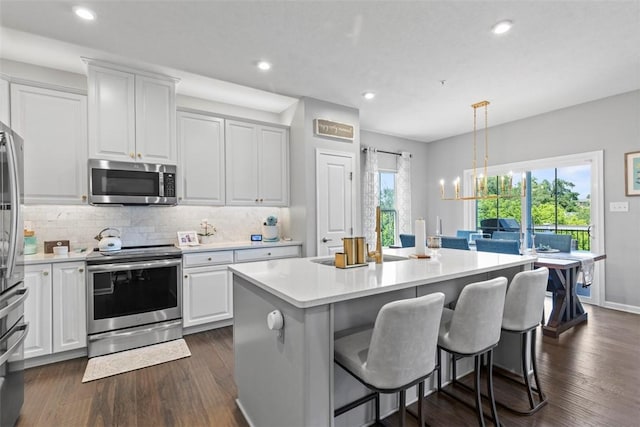 134 Black Oak Ln, Cecil, PA 15057 - kitchen with appliances with stainless steel finishes, light countertops, white cabinetry, a kitchen island with sink, and decorative backsplash