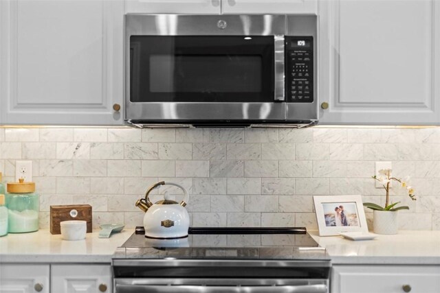 134 Black Oak Ln, Cecil, PA 15057 - kitchen featuring stainless steel appliances, white cabinets, light countertops, and tasteful backsplash
