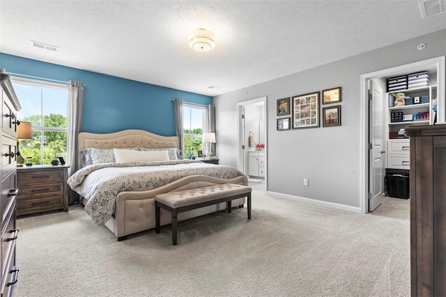 134 Black Oak Ln, Cecil, PA 15057 - bedroom featuring light carpet, a textured ceiling, connected bathroom, and a spacious closet