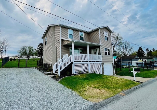 39 Delmont Ave, Delmont, PA 15626 - view of front facade with a porch, concrete driveway, a front lawn, a garage, and stairway
