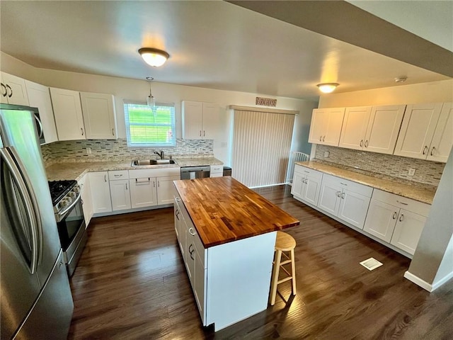 39 Delmont Ave, Delmont, PA 15626 - kitchen featuring stainless steel appliances, butcher block countertops, tasteful backsplash, white cabinets, and dark wood-type flooring