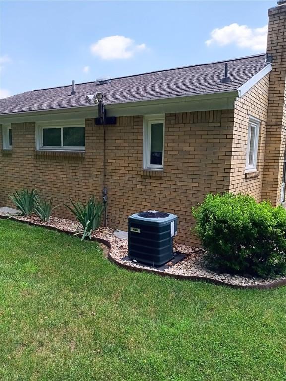 914 Woodland Ave, Port Vue, PA 15133 - view of home's exterior featuring brick siding, a lawn, a chimney, and a shingled roof