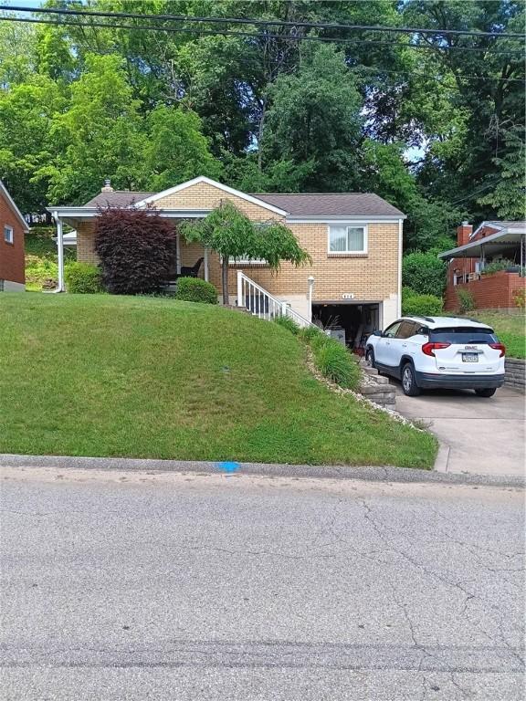 914 Woodland Ave, Port Vue, PA 15133 - view of front facade featuring a garage, driveway, and a front yard