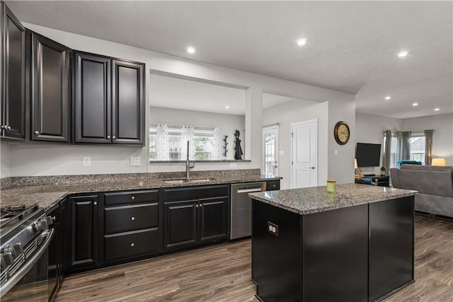 215 Saddle Ridge Dr, North Fayette, PA 15071 - kitchen with dishwasher, black range with gas cooktop, dark cabinetry, a kitchen island, and wood finished floors