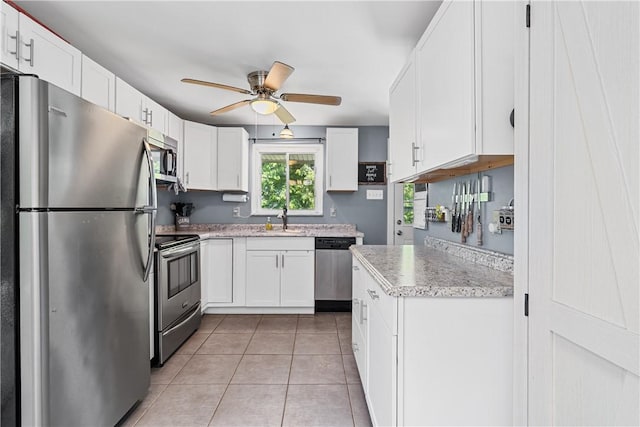 135 Taylor Run Rd, Carroll Twp, PA 15063 - kitchen with stainless steel appliances, a ceiling fan, white cabinetry, light tile patterned flooring, and light stone countertops