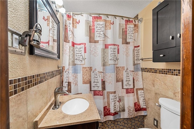 135 Taylor Run Rd, Carroll Twp, PA 15063 - bathroom featuring tile walls, vanity, a shower with shower curtain, a textured ceiling, and wainscoting