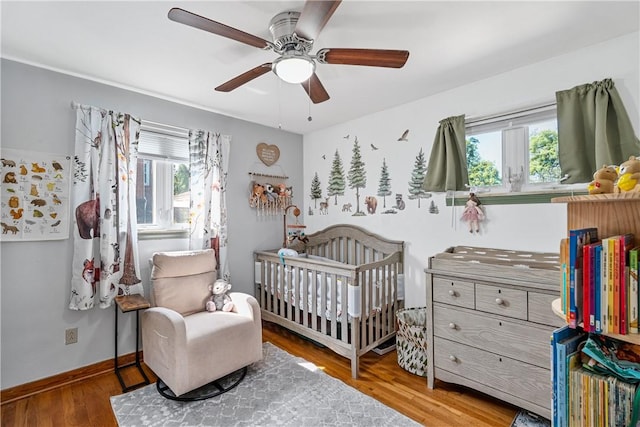 135 Taylor Run Rd, Carroll Twp, PA 15063 - bedroom featuring multiple windows, a nursery area, wood finished floors, and a ceiling fan