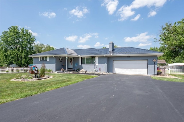 164 Seger Rd, Derry Twp, PA 15627 - single story home featuring asphalt driveway, a garage, a metal roof, a chimney, and a standing seam roof