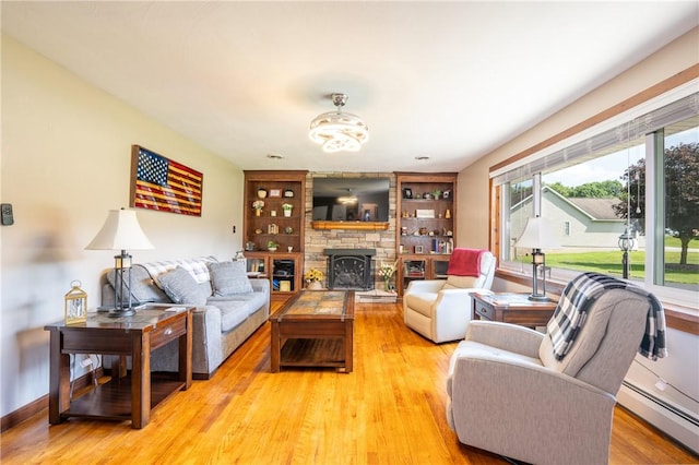 164 Seger Rd, Derry Twp, PA 15627 - living area with a baseboard heating unit, light wood-type flooring, and a stone fireplace