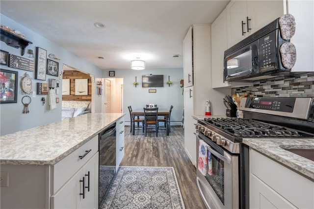 164 Seger Rd, Derry Twp, PA 15627 - kitchen with black appliances, dark wood-type flooring, white cabinetry, a center island, and light stone countertops