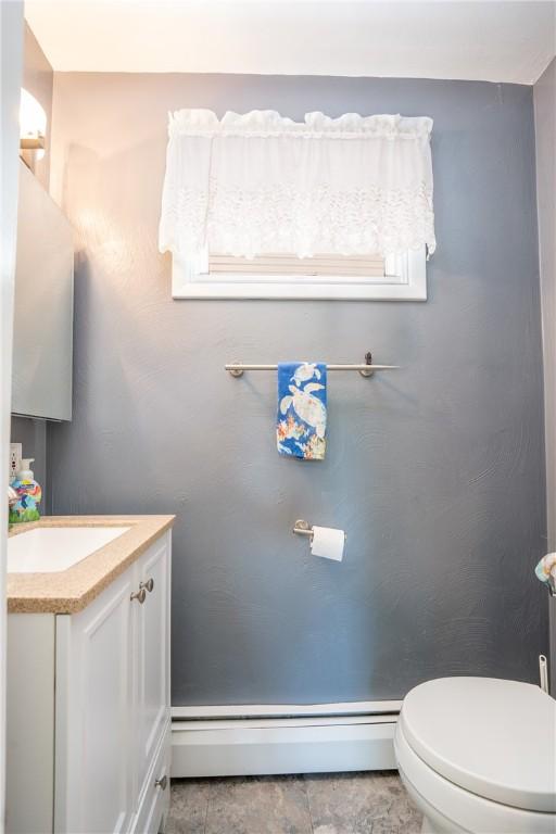 164 Seger Rd, Derry Twp, PA 15627 - half bath with a baseboard heating unit, vanity, healthy amount of natural light, and tile patterned flooring