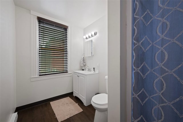 3520 Butler St, Lawrenceville, PA 15201 - bathroom with vanity, wood finished floors, a shower with shower curtain, and a baseboard radiator