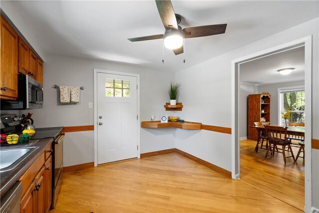 5934 Barnes Ave, Bethel Park, PA 15102 - kitchen with stainless steel appliances, light wood-style flooring, brown cabinetry, a ceiling fan, and dark countertops
