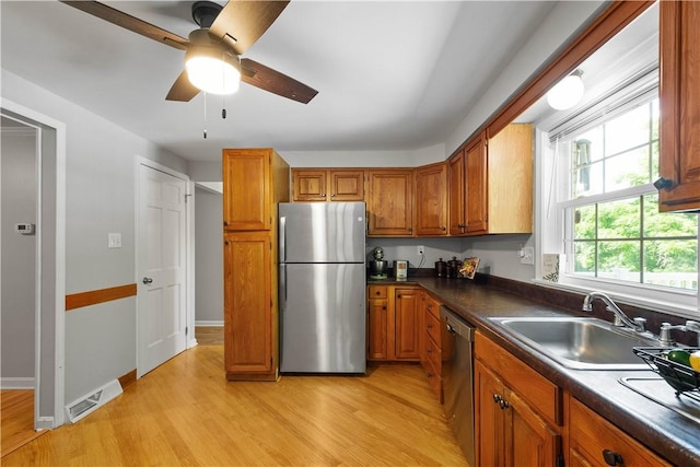 5934 Barnes Ave, Bethel Park, PA 15102 - kitchen featuring appliances with stainless steel finishes, light wood-type flooring, brown cabinetry, and dark countertops