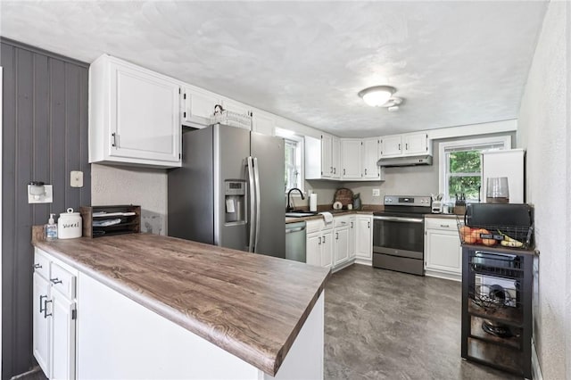 476 Trees Mills Rd, Salem Twp, PA 15601 - kitchen with appliances with stainless steel finishes, a peninsula, white cabinetry, and under cabinet range hood